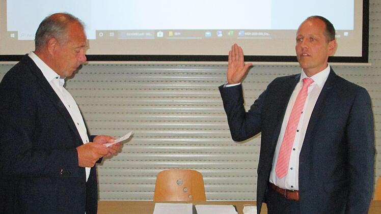 Den neuen Bürgermeister des Marktes Elfershausen, Johannes Krumm (r.) vereidigte der dienstälteste Gemeinderat Jürgen Englert (l.).