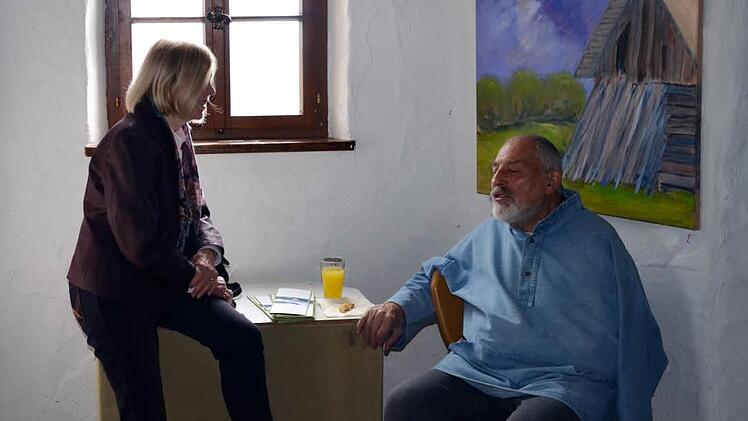 Künstler Erhard Schütze spricht mit einer Besucherin. Foto: Andrea Spörlein