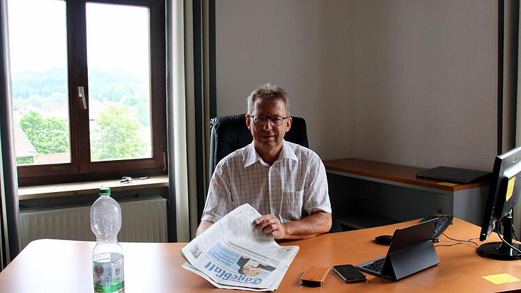 Über den aufgeräumten Schreibtisch und Zeit zum Zeitungslesen kann sich Weitramsdorfs Bürgermeister Wolfgang Bauersachs (BfB) nur kurz freuen: Der Inhalt seines Büros ist für den Umzug in die ehemalige Weidacher Grundschule bereits in Kisten verpackt, die Telefonanlage abgestellt. Und die Verwaltung hat bis einschließlich Freitag geschlossen. Foto: Bettina Knauth