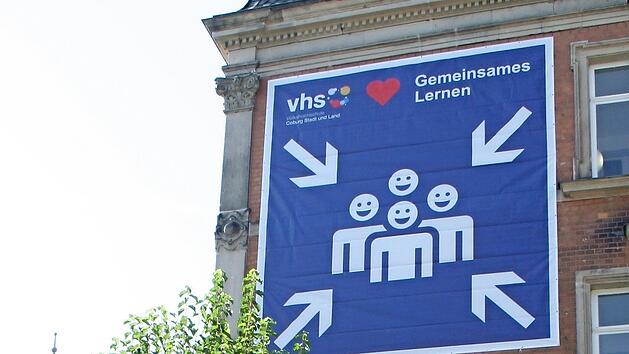 Das Logo-Banner am Haus der Volkshochschule in der L&ouml;wenstra&szlig;e 16 zeigt: Die Kurse gehen wieder los, und m&ouml;glichst alle sollten zusammen lernen k&ouml;nnen.