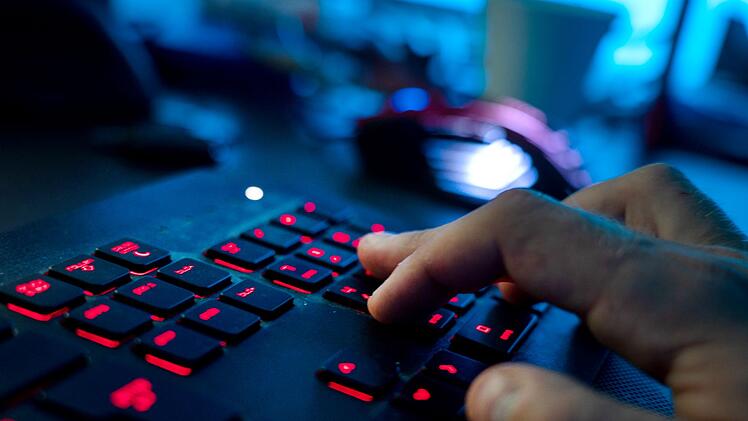 Ein Mann sitzt am Rechner und tippt auf einer Tastatur