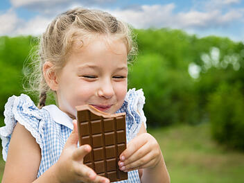 Schokolade Gl&uuml;ck Gl&uuml;cksgef&uuml;hl Endorphine Dopamin Serotonin Kakao Flavonoide Genuss S&uuml;&szlig;igkeit Naschen M&auml;dchen jung L&auml;cheln Freude Stimmung GuteLaune Stressabbau Belohnung Achtsamkeit Genussmoment Snack Dessert Milchschokolade Zartbitterschokolade Gesundheit Wohlbefinden Emotionen Lifestyle Wissenschaft Joyful girl eating chocolate