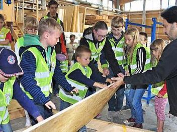 Am "Türöffner-Tag" der "Sendung mit der Maus" in der Firma "HolzVogel" durften die Kinder auch beim Bau eines Getreidespeichers für die "Maus" helfen. Mit im Bild Martin Willun von der Firma "HolzVogel" (rechts), der die kindgerechten Führungen übernahm.  Foto: Ulrike Langer