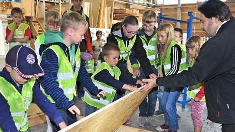 Am "Türöffner-Tag" der "Sendung mit der Maus" in der Firma "HolzVogel" durften die Kinder auch beim Bau eines Getreidespeichers für die "Maus" helfen. Mit im Bild Martin Willun von der Firma "HolzVogel" (rechts), der die kindgerechten Führungen übernahm.  Foto: Ulrike Langer