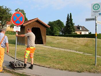 Die Mitarbeiter des gemeindlichen Bauhofs stellen im Stangenrother Birkenweg eine Schild auf. Hier darf am Freitag nicht geparkt und nicht gehalten werden.