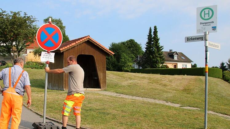 Die Mitarbeiter des gemeindlichen Bauhofs stellen im Stangenrother Birkenweg eine Schild auf. Hier darf am Freitag nicht geparkt und nicht gehalten werden.