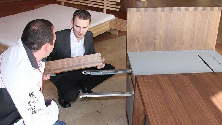 Gerne gaben die jungen Schreinermeister Auskunft über ihre Meisterstücke, wie hier Bernd Stelzer, der einem Besucher den aus Eiche gefertigten Sekretär "Deerleg" erläutert. Foto: Helmut Will