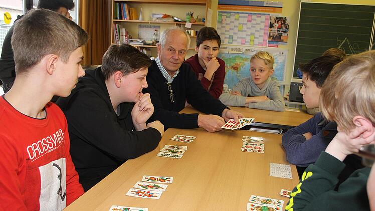 In Vierergruppen spielen die Siebt- und Achtklässler Schafkopf. Nicht nur zum Spaß, denn der Leiter der Stadtsteinacher Hauptschule, Michael Pfitzner, will mit dem Kurs auch verhindern, dass die fränkische Tradition verloren geht. Foto: Sonny Adam