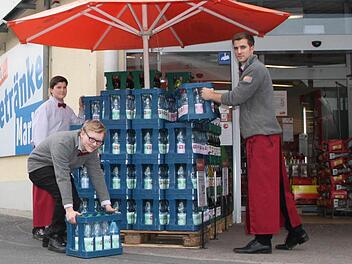 Bei der Arbeit: Jan Halbig (von links nach rechts), Niklas Enders und Jonas Winkler stapeln Kästen vor dem Eingang zum Getränkemarkt vom Tegut am Gänsrain in Bad Brückenau. Foto: Ulrike Müller