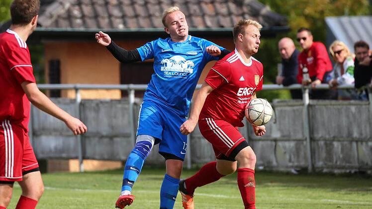 Bereits bei der Ballannahme wird der Johannisthaler Christopher Gro&szlig;mann (rot) von Eugen Lorenz gest&ouml;rt. Foto: Heinrich Wei&szlig;