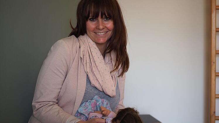 Physiotherapeutin Carolin Steiner demonstriert eine Lagerungsübung für Babys an einer Puppe.