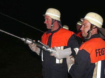 An der Spitze der über 650 Meter langen Schlauchstrecke freuten sich die Feuerwehrleute, als es "Wasser marsch!" hieß und der Löscheinsatz mit Wasser aus dem Hochbehälter beginnen konnte. Die Dunkelheit erhöhte den Schwierigkeitsgrad der Übung. Foto: Gerd Schaar