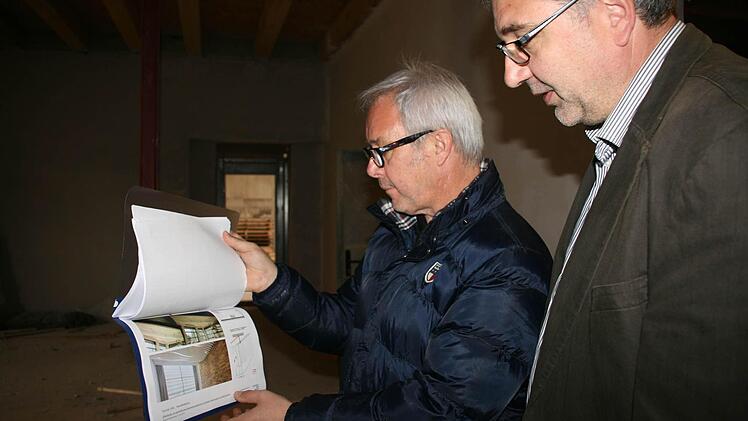 Wie es nach dem Innenausbau aussehen soll, zeigen Walter Böhm und Matthias Kurth anhand von Zeichnungen. Natürlich werden dabei Holz und Gips eine Rolle spielen. Foto: Daniela Röllinger