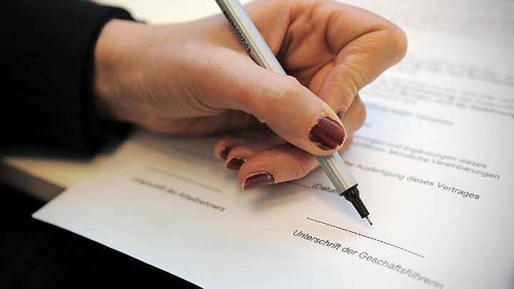 Unterzeichnung eines Vertrags: Hat der Angeklagte hier tatsächlich mit falschen Angaben Kunden und Arbeitgeber betrogen?  Foto: Jan-Philipp Strobel/dpa