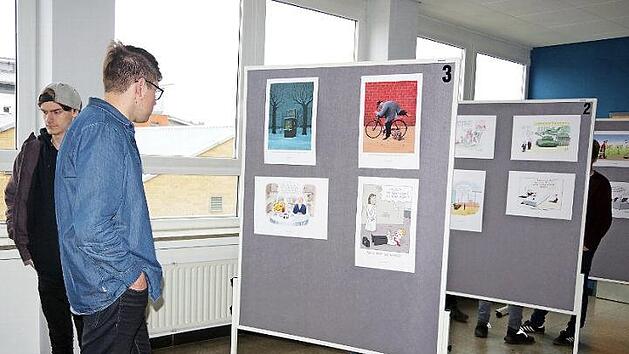 Berufssch&uuml;ler betrachten die Karikaturen der Ausstellung "Arbeit ist das halbe Leben!?"  Foto: Heike Sch&uuml;lein