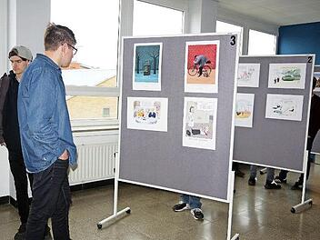 Berufsschüler betrachten die Karikaturen der Ausstellung "Arbeit ist das halbe Leben!?"  Foto: Heike Schülein