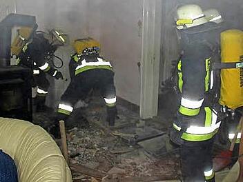 Pressiger Feuerwehrleute am Brandherd im Turmzimmer der Villa. Der so genannte "Fehlboden" wird aufgehackt, um an den Brandherd zu kommen.  Foto: Schedel