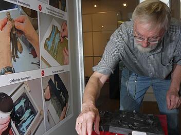 So fängt alles an: Günter Rohn bestückt eine Vitrine mit Gegenständen, die am Anfang bei der Entwicklung einer Figur gebraucht werden - Wachsmodelle und Gussformen. Foto: Berthold Köhler