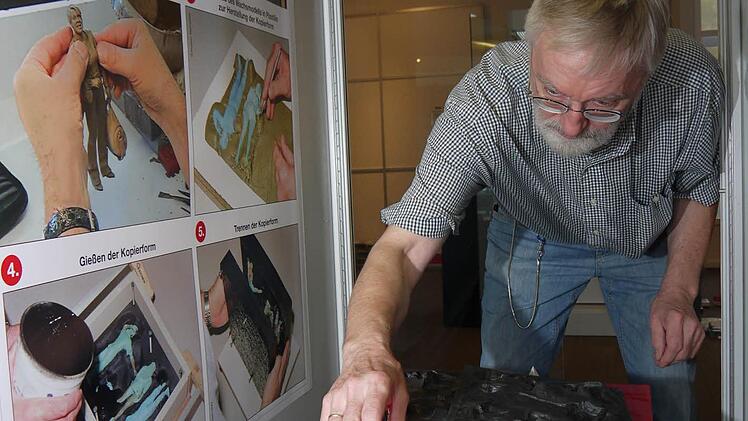 So fängt alles an: Günter Rohn bestückt eine Vitrine mit Gegenständen, die am Anfang bei der Entwicklung einer Figur gebraucht werden - Wachsmodelle und Gussformen. Foto: Berthold Köhler
