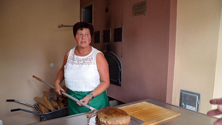 Birgit Heilmann zeigt das erste selbstgebackene Brot aus dem Mühlendorfer Backhaus. Foto: Andrea Spörlein