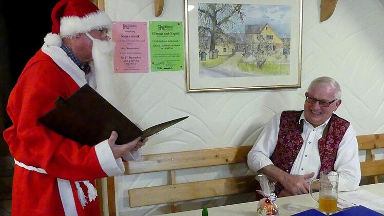 Der Nikolaus (Jochen Scholz) hatte auch für den Hausherrn Dieter Eschenbacher ein Geschenk. Foto Dieter Hübner