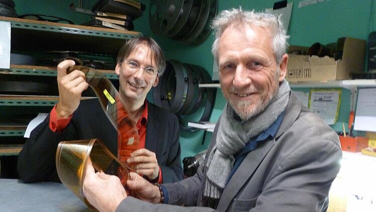 Das gibt's noch?! Bruno Schneyer (rechts) hält im Vorführraum der "Schauburg" von Clemens Scherer einen 70-Millimeter-Kinofilm in der Hand. Die "Schauburg" verfügt noch über einen voll funktionsfähigen Projektor. Foto: Kino-Schneyer