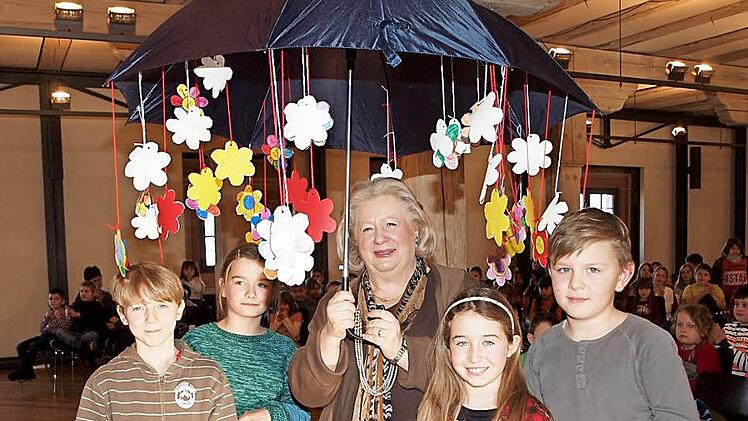 Die Schüler der beiden dritten Klassen überreichten Gertrud Tischer einen Regenschirm, an dem ein Blumenregen voller guter Wünsche niederging. Foto: Alfred Thieret