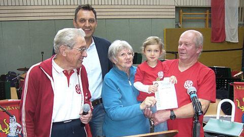 Viel Beifall gab es bei der Auszeichnung der erst vierjährigen Sophie Hohlweg. Im Bild (von links): Wander-Abteilungsleiter Günter Kaim, Vorsitzender Jörg Neubauer, die Vizepräsidentin des Deutschen Volkssportverbandes Betty Berdami und Sophie Hohlweg auf dem Arm ihres Opas Valentin Gampert. Fotos: Dieter Wolf