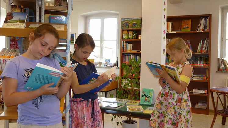 Ganz schön spannend: Vertieft in ihren Büchern lesen (von links) Marie Angebrand, Lisa Tully und Melissa Krines in der Sander Pfarrbücherei.