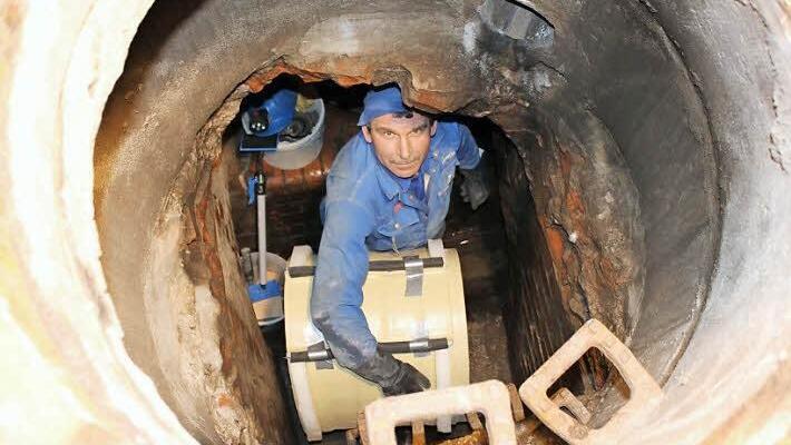 Valeri Gromow mit einem Teil der Schale, auf die das Rohr für das Schmutzwasser aufgelegt werden soll. Die Schalenteile haben unten "Füße", so dass sie nicht direkt auf dem Boden des Kanals aufliegen, sondern Platz für die Abführung des Grundwassers lassen. Fotos: Thomas Mäuser