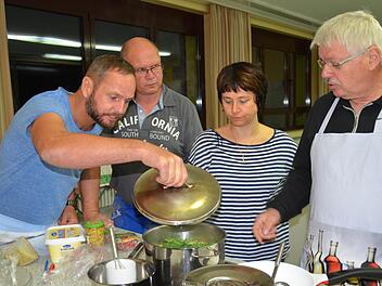 Topfgucken gehört beim Kochkurs der VHS Burkardroth dazu: Hier steht eine Kartoffelsuppe auf dem Herd. Michael Hauck (von links), Jaak Smits, Corinna Raab und Helmut Schneider besprechen die nächsten Schritte. Foto: Kathrin Kupka-Hahn