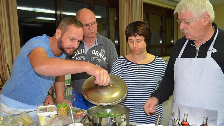 Topfgucken gehört beim Kochkurs der VHS Burkardroth dazu: Hier steht eine Kartoffelsuppe auf dem Herd. Michael Hauck (von links), Jaak Smits, Corinna Raab und Helmut Schneider besprechen die nächsten Schritte. Foto: Kathrin Kupka-Hahn
