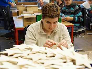 Anna Mützel fädelt die Schnüre in die Holzsterne ein. Foto: Arkadius Guzy