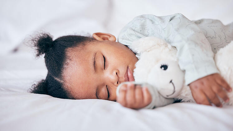 Black child, baby and sleeping with toy in bedroom, home and nursery for peace, calm nap and dreaming. Tired young girl kid asleep with teddy bear for resting, break and healthy childhood development