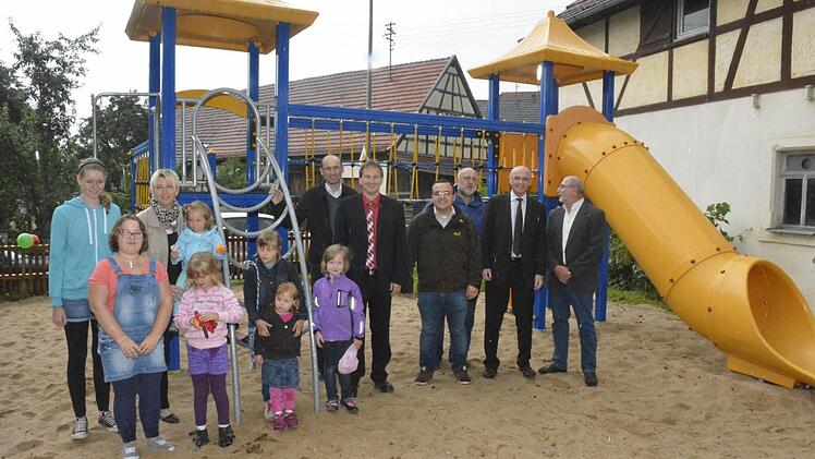 Es dauerte nicht lange und die Kinder hatten den neuen Spielplatz in Beschlag genommen. Mit den Jüngsten des Dorfes im Bild (von links): Gemeinderätin Heidi Müller-Gärtner, Pfarrer Martin Popp-Posekardt, Bürgermeister Wolfram Thein, Stefan Böhm, Gerd-Peter Schmidt, Leiter des Bauhofs, Landrat Wilhelm Schneider und Hans Merz.  Foto: Schmidt