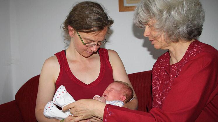 Mit einfachen Handgriffen zeigt Hebamme Karin Balke der frisch gebackenen Mutter Anne Kruse, wie Säuglinge sich am besten beruhigen lassen.