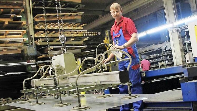 Mitarbeiter Alexander Schwan hebt eine Metallplatte vom Stapel, um diese im Laser zuschneiden zu lassen. Fotos: Thomas Heuchling