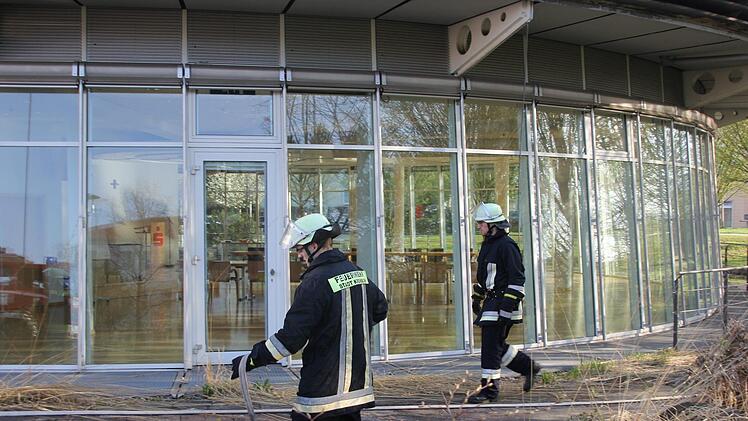 Zwei Feuerwehrleute rollen die Wasserschläuche zusammen. Foto: Andreas Schmitt