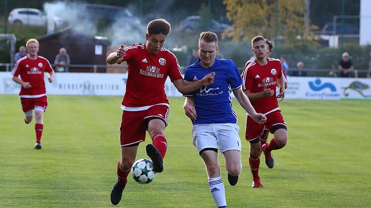 Leon Pietsch und Tim Knoch vom TSV Meeder (rot) kommen gegen Daniel Oppel zu spät.