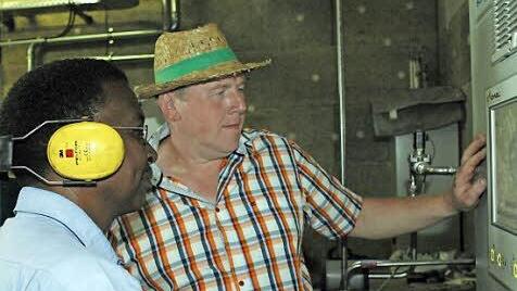 Geschäftsführer Albert Sebald erläutert Dekan Malaki Joel Pallangyo die Steuerung der Biogasanlage.