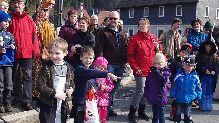 Die Zaungäste am Wegrnd genießen die Stimmung und packen Süßigkeiten in die mitgebrachten Beutel.