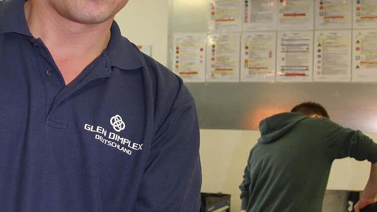 Ausbildungsleiter Helmut Lauterbach von Glen Dimplex zeigt, wie die fertige "Edelstein"-Spinne aussehen soll.