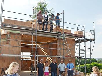 Ein freudiger Tag für Feuerwehr, Bürger und Kinder war das Richtfest für das Feuerwehrhaus. Auf dem Gerüst Bauleiter Markus Renner (rechts), der Süßigkeiten verteilte, Zimmermann Tobias Döring (2.v. l.) und unten vor dem Feuerwehrhaus, v. l. Kommandant Peter Fischer, Beate Renner, Erich Reis (Vorsitzender), Gerhard Sesselmann, 2. Kommandant, Bürgermeister Bernd Rebhan Foto: K.- H. Hofmann
