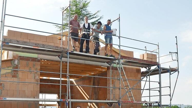 Ein freudiger Tag für Feuerwehr, Bürger und Kinder war das Richtfest für das Feuerwehrhaus. Auf dem Gerüst Bauleiter Markus Renner (rechts), der Süßigkeiten verteilte, Zimmermann Tobias Döring (2.v. l.) und unten vor dem Feuerwehrhaus, v. l. Kommandant Peter Fischer, Beate Renner, Erich Reis (Vorsitzender), Gerhard Sesselmann, 2. Kommandant, Bürgermeister Bernd Rebhan Foto: K.- H. Hofmann