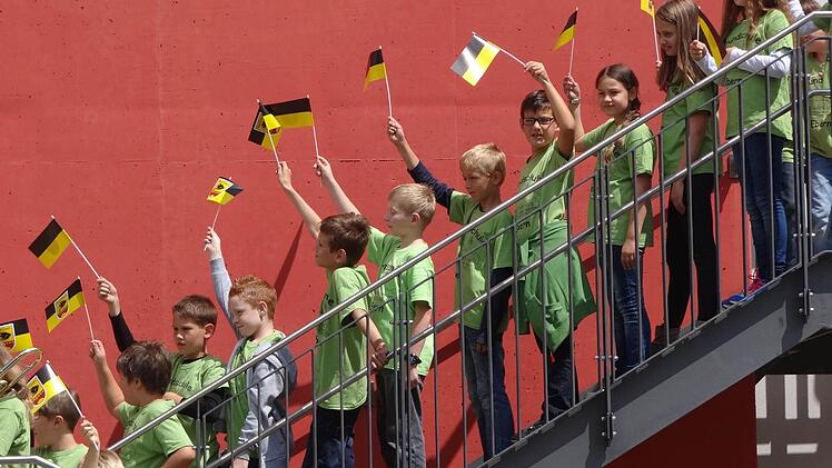 Mit wedelnden Ebern-Fähnchen begrüßte die Schulfamilie ihre Gäste zum Schulfest im Pausenhof.