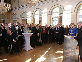 Oberbürgermeister Norbert Tessmer (ganz rechts) spricht im vollgefüllten Spiegelsaal des Landestheaters. Foto: Simone Bastian