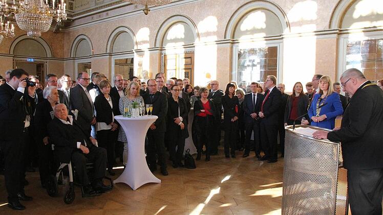 Oberbürgermeister Norbert Tessmer (ganz rechts) spricht im vollgefüllten Spiegelsaal des Landestheaters. Foto: Simone Bastian