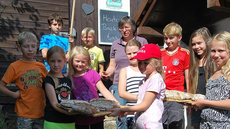 Beim Ferienprogramm mit der Eigenheimervereinigung Maßbach haben zehn Kinder im selbst gemauerten Holzbachofen der Familie Metzner Brot und andere Spezialitäten gebacken.  Foto: Eigenheimervereinigung