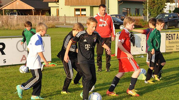 Frank Gareis (im Hintergrund) beaufsichtigt auf dem Sportgelände des FC Haßlach einen Teil seiner Schützlinge. Foto: Herbert Kalb