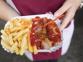Kommt zwar aus der Hauptstadt, ist aber auch in Franken beliebt - die Currywurst mit Pommes. Symbolfoto: Jörg Carstensen/dpa